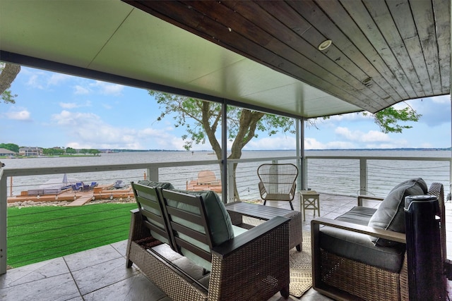 view of patio featuring a water view, an outdoor living space, and a balcony
