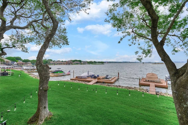 dock area featuring a lawn and a water view