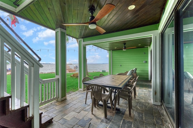sunroom / solarium featuring outdoor dining area, a water view, and ceiling fan