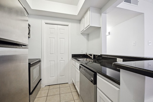 kitchen with light tile patterned flooring, visible vents, a sink, white cabinetry, and stainless steel appliances