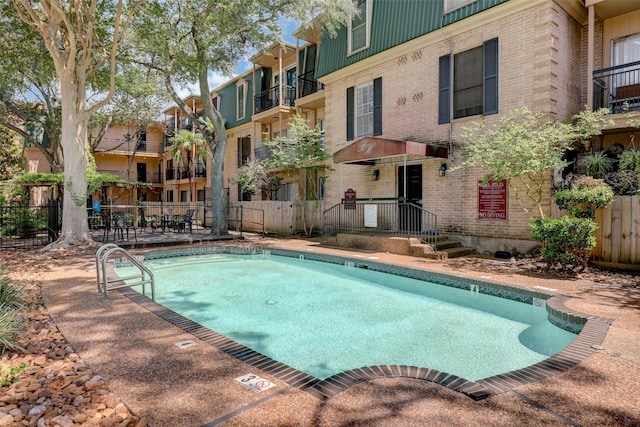 pool with fence and a residential view
