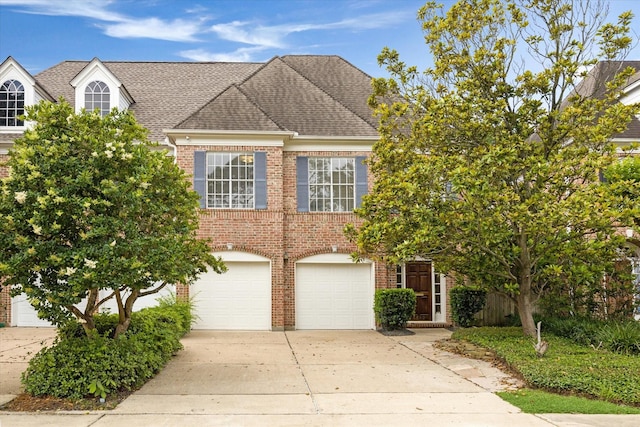 view of front of house featuring concrete driveway, brick siding, roof with shingles, and an attached garage