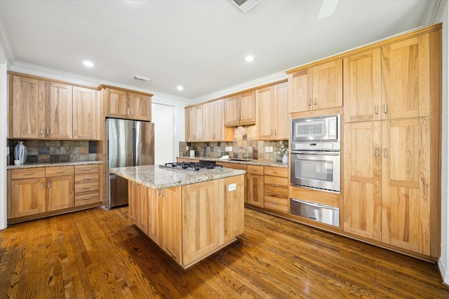 kitchen featuring a sink, a kitchen island, backsplash, a warming drawer, and appliances with stainless steel finishes