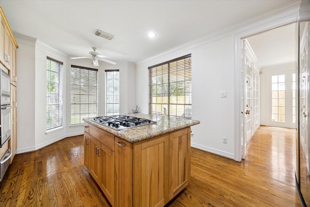 kitchen featuring wood finished floors, baseboards, visible vents, and appliances with stainless steel finishes