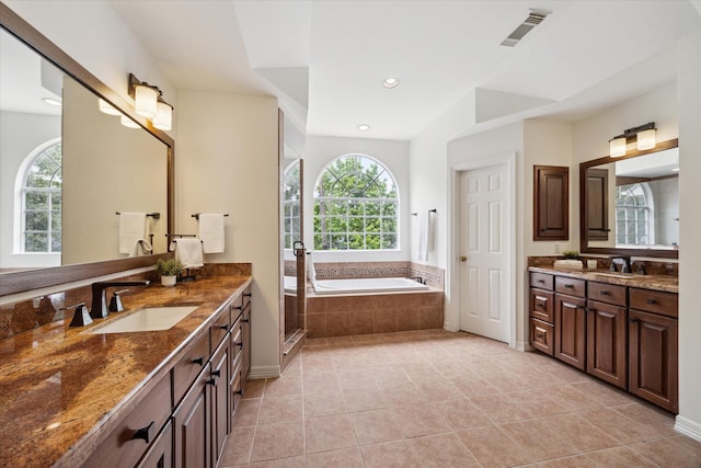 bathroom featuring a sink, tile patterned flooring, a garden tub, and visible vents