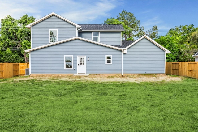 rear view of property featuring a yard, a fenced backyard, roof with shingles, and central air condition unit