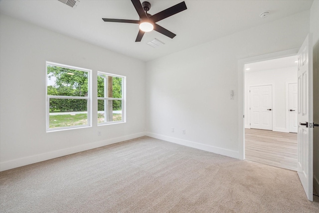 unfurnished room featuring baseboards, ceiling fan, visible vents, and light colored carpet