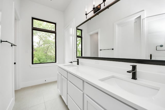 bathroom featuring a sink, tile patterned floors, baseboards, and double vanity