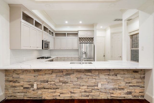 6115 Hamman St, Houston, TX 77007 - kitchen featuring stainless steel appliances, light stone countertops, backsplash, a peninsula, and crown molding
