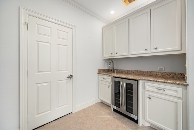 6115 Hamman St, Houston, TX 77007 - indoor wet bar with beverage cooler, light tile patterned floors, baseboards, and crown molding