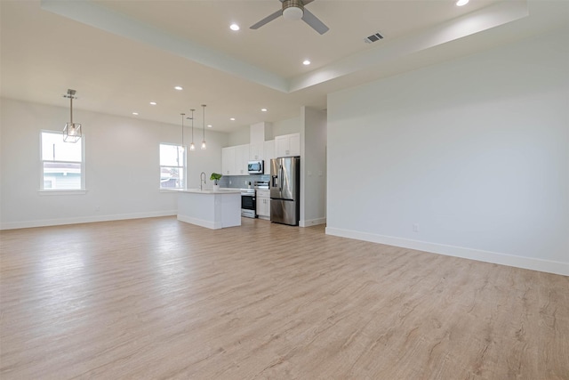 4206 Mason Dr, Galveston, TX 77554 - unfurnished living room featuring recessed lighting, baseboards, a sink, and light wood-style flooring