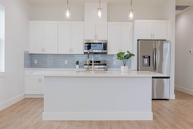 4206 Mason Dr, Galveston, TX 77554 - kitchen with light countertops, decorative backsplash, stainless steel appliances, and an island with sink