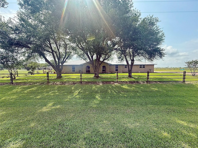 view of yard featuring fence and a rural view