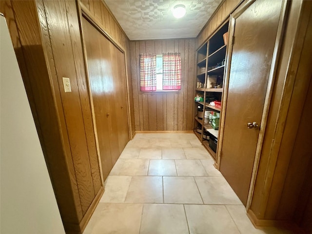entryway featuring wood walls and light tile patterned flooring