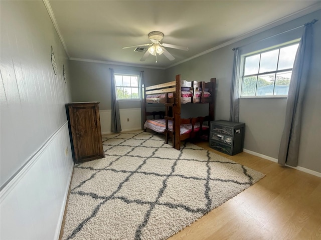 bedroom featuring crown molding, a ceiling fan, light wood-type flooring, and visible vents