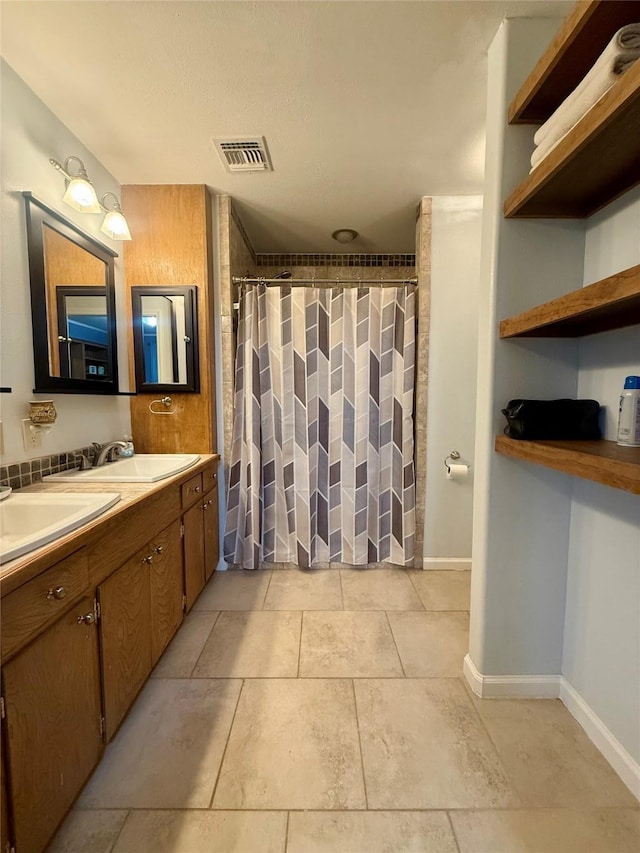 bathroom featuring a sink, a shower with curtain, tile patterned flooring, and visible vents