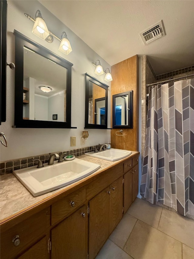full bathroom with a sink, tile patterned flooring, double vanity, and visible vents