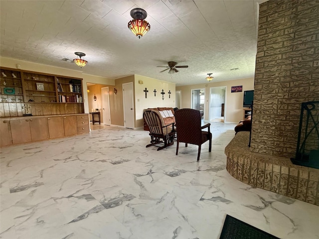 living room with baseboards and ceiling fan