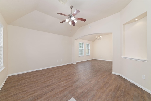 unfurnished room with arched walkways, vaulted ceiling, wood finished floors, baseboards, and ceiling fan with notable chandelier