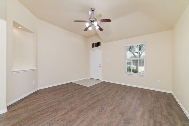 spare room with a ceiling fan, baseboards, wood finished floors, vaulted ceiling, and visible vents