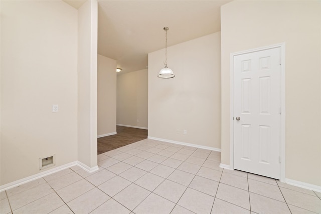 empty room featuring light tile patterned flooring and baseboards
