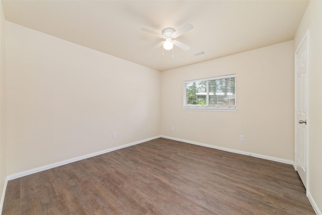 spare room with baseboards, ceiling fan, visible vents, and wood finished floors