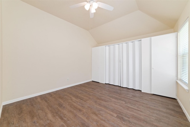 unfurnished bedroom with a ceiling fan, baseboards, wood finished floors, and lofted ceiling