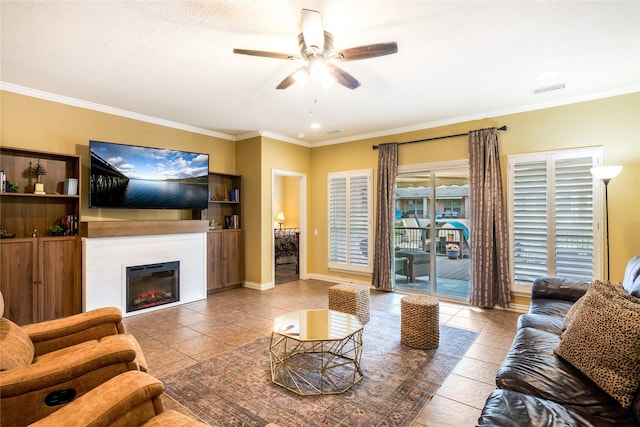 11068 First Lgt, Montgomery, TX 77356 - tiled living area with a ceiling fan, visible vents, baseboards, a glass covered fireplace, and ornamental molding