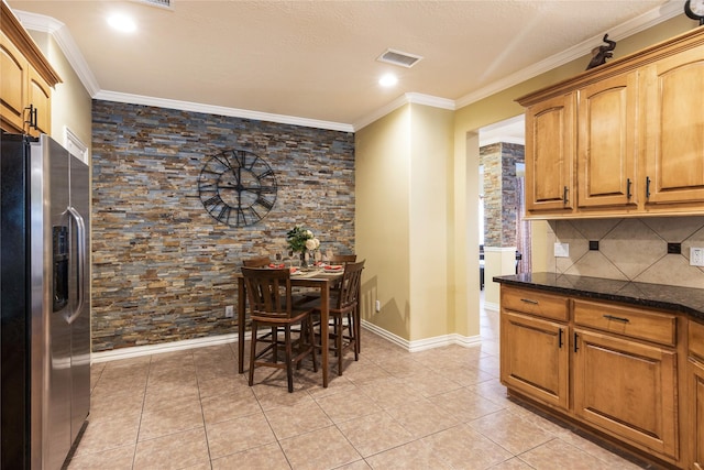 11068 First Lgt, Montgomery, TX 77356 - kitchen featuring crown molding, visible vents, stainless steel refrigerator with ice dispenser, dark stone countertops, and light tile patterned floors