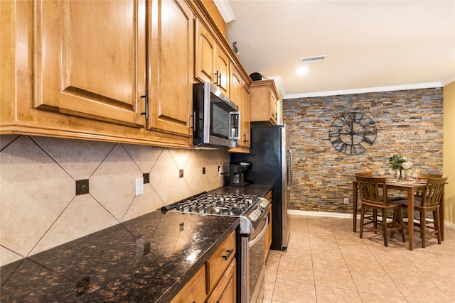 11068 First Lgt, Montgomery, TX 77356 - kitchen with decorative backsplash, visible vents, crown molding, light tile patterned floors, and stainless steel appliances