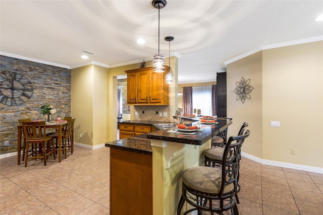 11068 First Lgt, Montgomery, TX 77356 - kitchen featuring a peninsula, ornamental molding, light tile patterned floors, and a kitchen bar