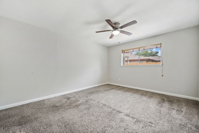 carpeted empty room featuring a ceiling fan and baseboards