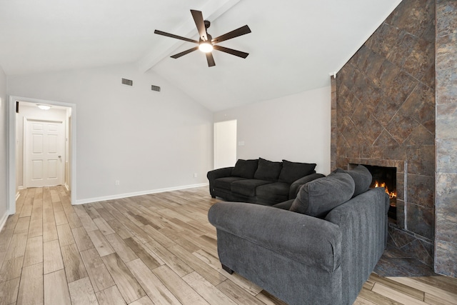 living room featuring lofted ceiling with beams, a large fireplace, a ceiling fan, light wood-type flooring, and visible vents