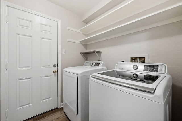 laundry room with dark wood-style flooring, laundry area, and washer and clothes dryer