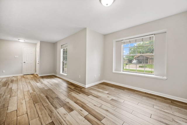 unfurnished room with baseboards and wood finished floors