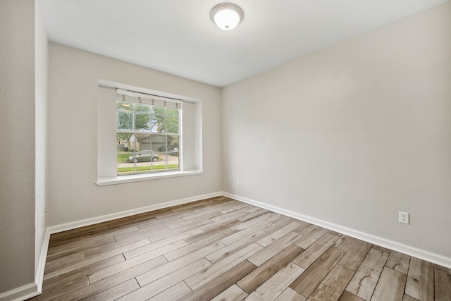 unfurnished room with baseboards and wood finished floors