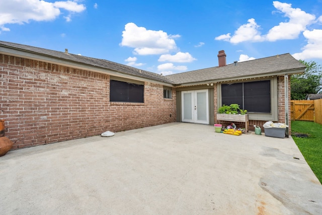 exterior space featuring french doors, fence, a patio area, and brick siding
