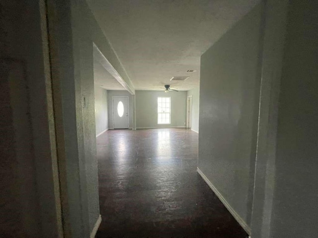 hall featuring baseboards and visible vents