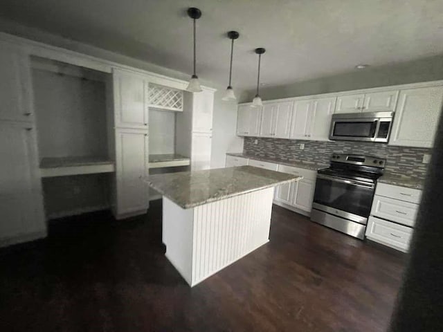 kitchen with decorative backsplash, a kitchen island, dark wood-type flooring, white cabinets, and stainless steel appliances