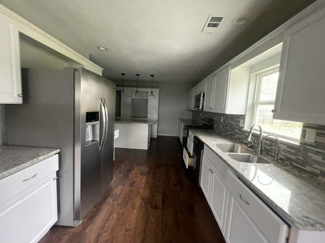 kitchen with dark wood-style flooring, a sink, stainless steel appliances, backsplash, and visible vents