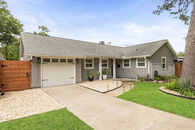 ranch-style home with roof with shingles, fence, an attached garage, and concrete driveway