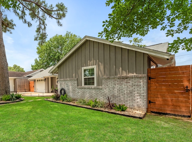 view of front of house with board and batten siding, brick siding, a front yard, and a garage