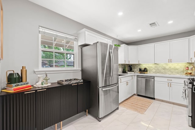 kitchen with recessed lighting, white cabinetry, appliances with stainless steel finishes, and backsplash