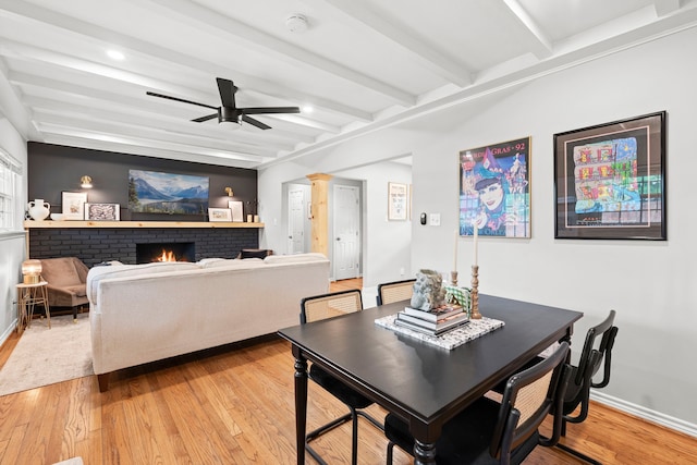 dining space with baseboards, ceiling fan, beam ceiling, and light wood-type flooring