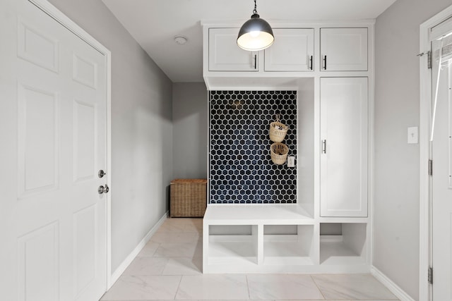 mudroom with baseboards and marble finish floor