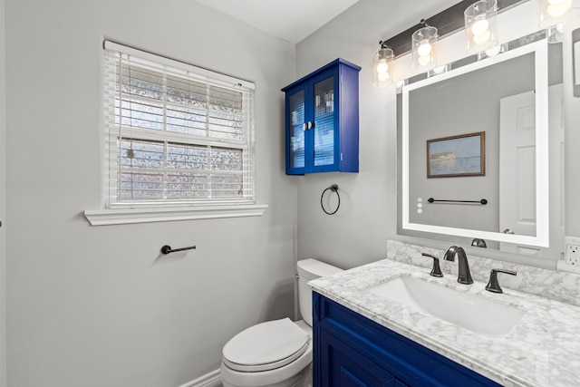 bathroom featuring toilet, baseboards, and vanity