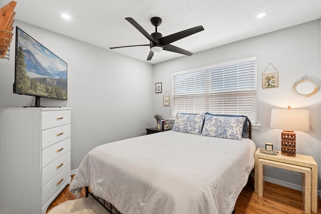 bedroom with a ceiling fan, baseboards, recessed lighting, and wood finished floors