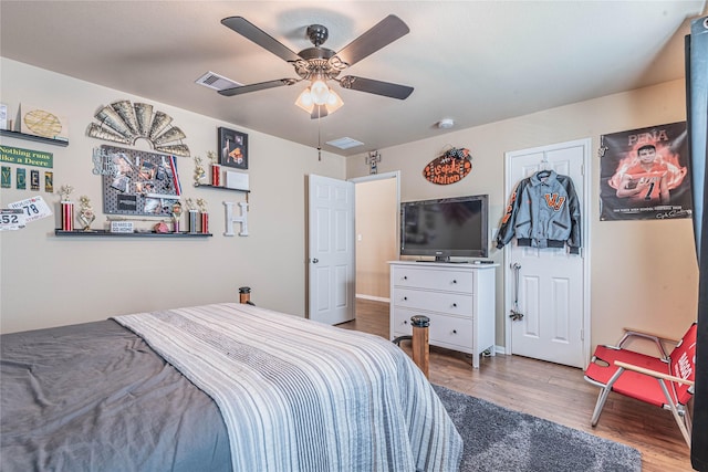 bedroom with visible vents, baseboards, ceiling fan, and wood finished floors