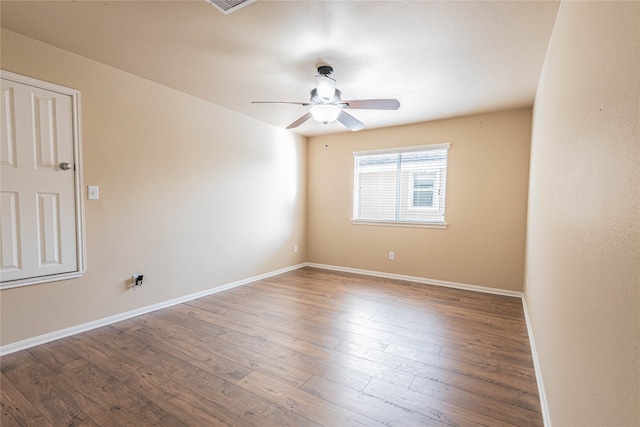 empty room with a ceiling fan, baseboards, and wood finished floors