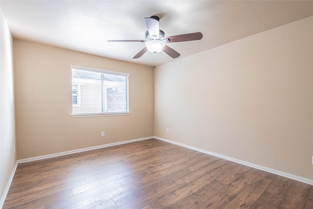 spare room with baseboards, a ceiling fan, and wood finished floors